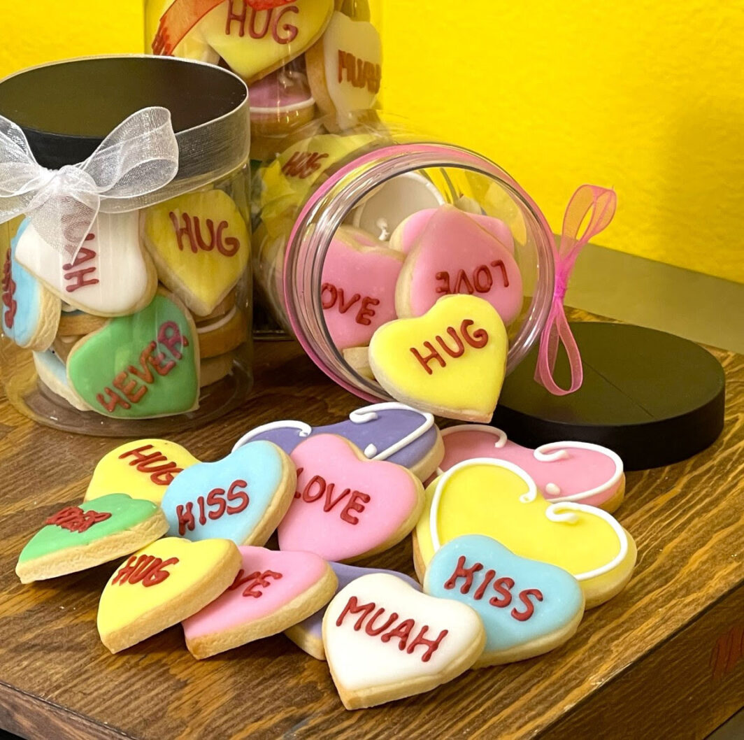 Different colored Valentines cookies in a jar.