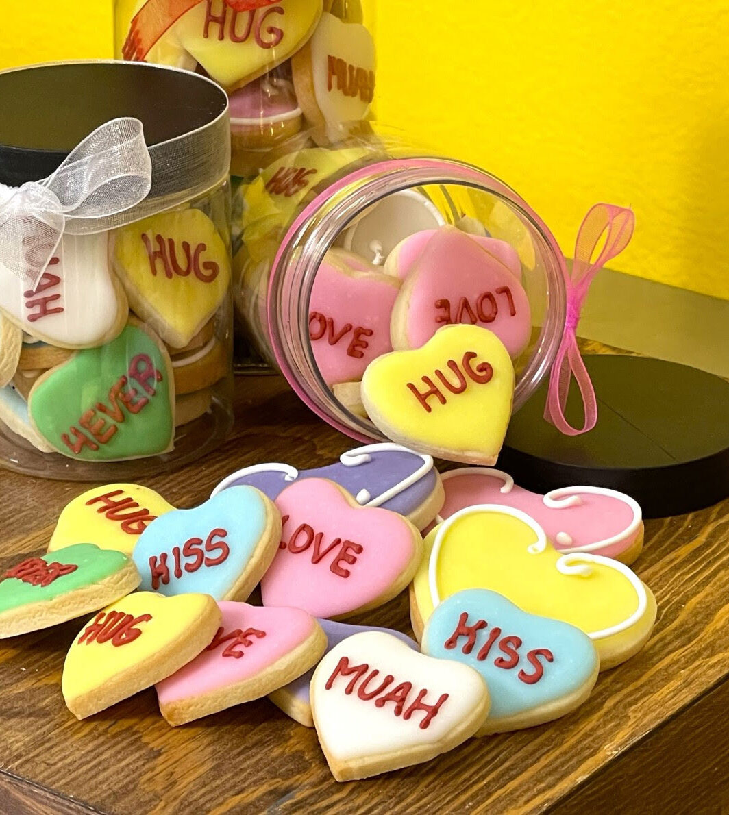 Different colored Valentines cookies in a jar.